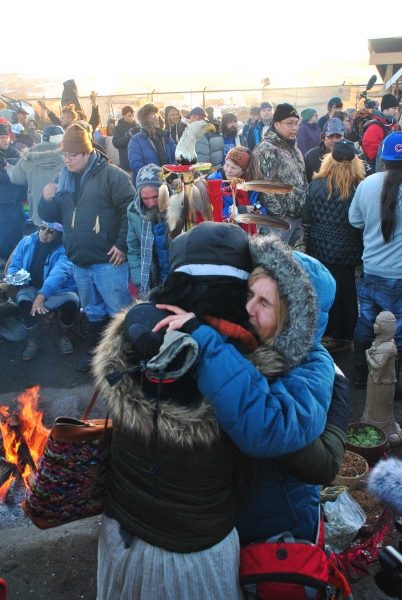 Activists hug each other during celebration of Standing Rock victory - photo by C.S. Hagen